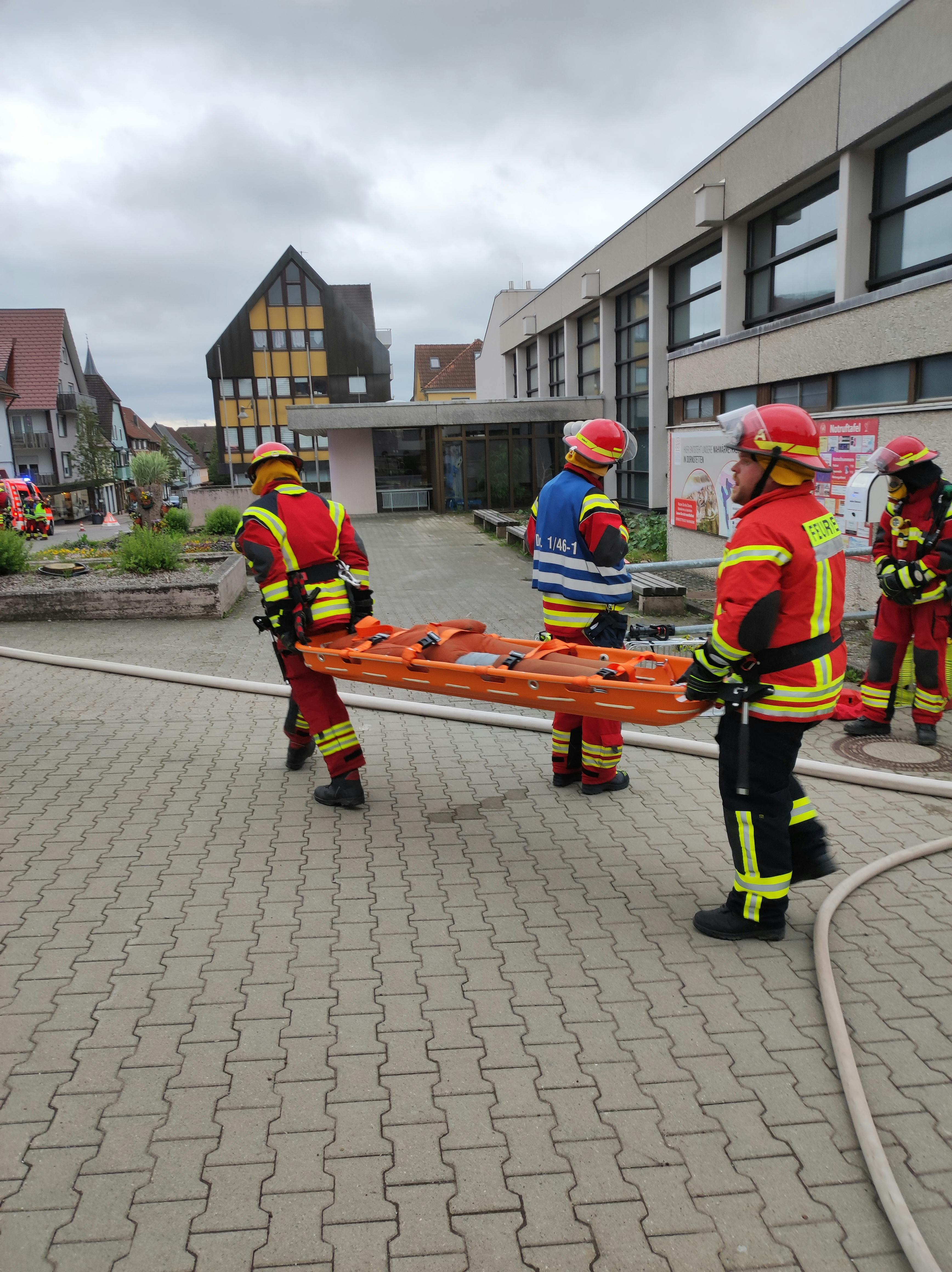 Eine gerettete Person kommt aus der Stadthalle